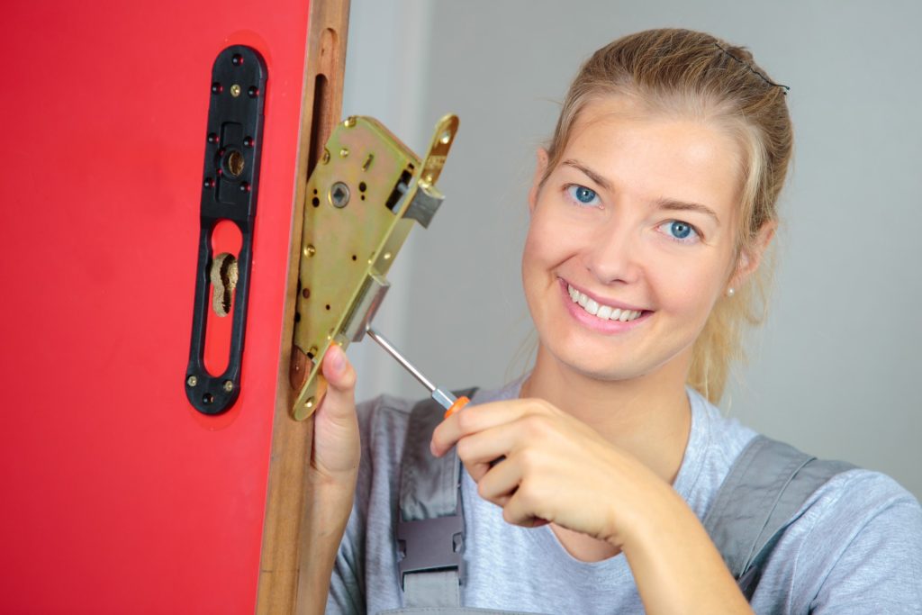 Femme réparant une serrure de porte